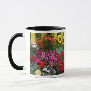 Yellow picket fence with flower garden in mug