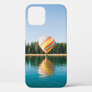 Yellow, red, and blue hot air balloon near trees a iPhone 12 case