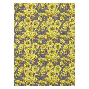 Yellow roses with grey leaves on orange tablecloth