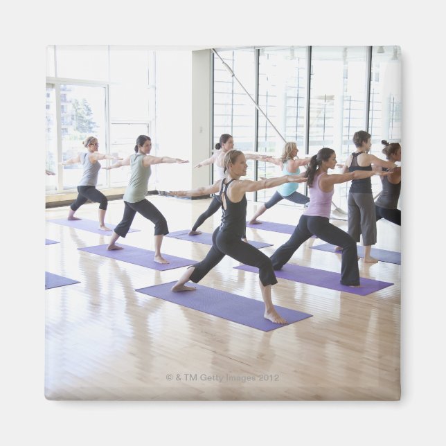 Yoga instructor teaching a class of women the magnet (Front)