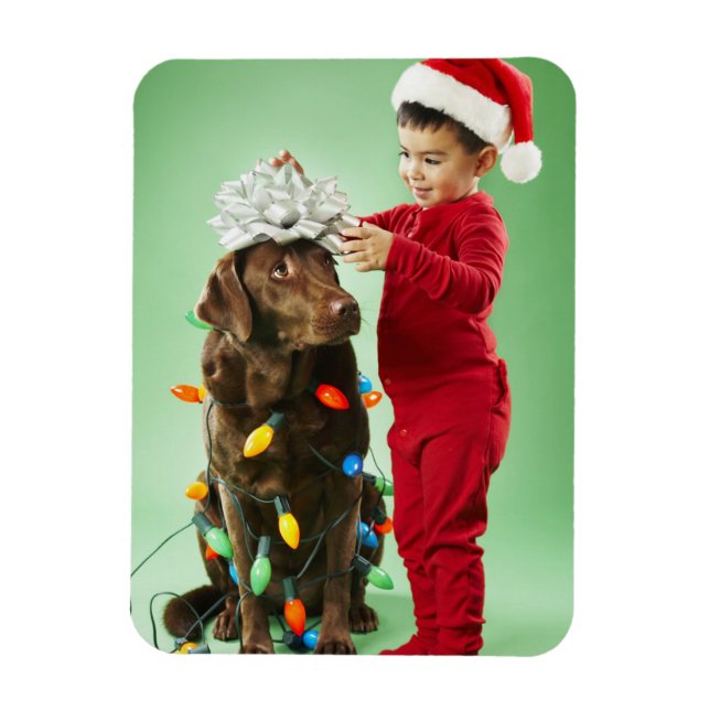 Young boy wrapping Christmas lights around a dog Magnet (Vertical)