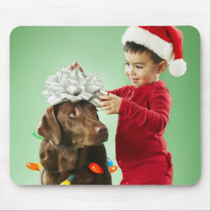 Young boy wrapping Christmas lights around a dog Mouse Pad