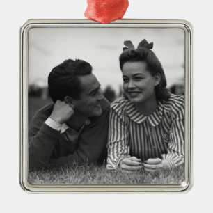 Young couple lying on grass metal ornament