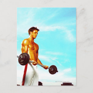 Young man exercising with barbells postcard