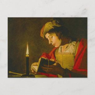 Young man reading by candlelight postcard