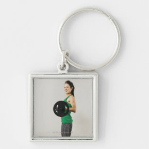 Young woman lifting a barbell. key ring